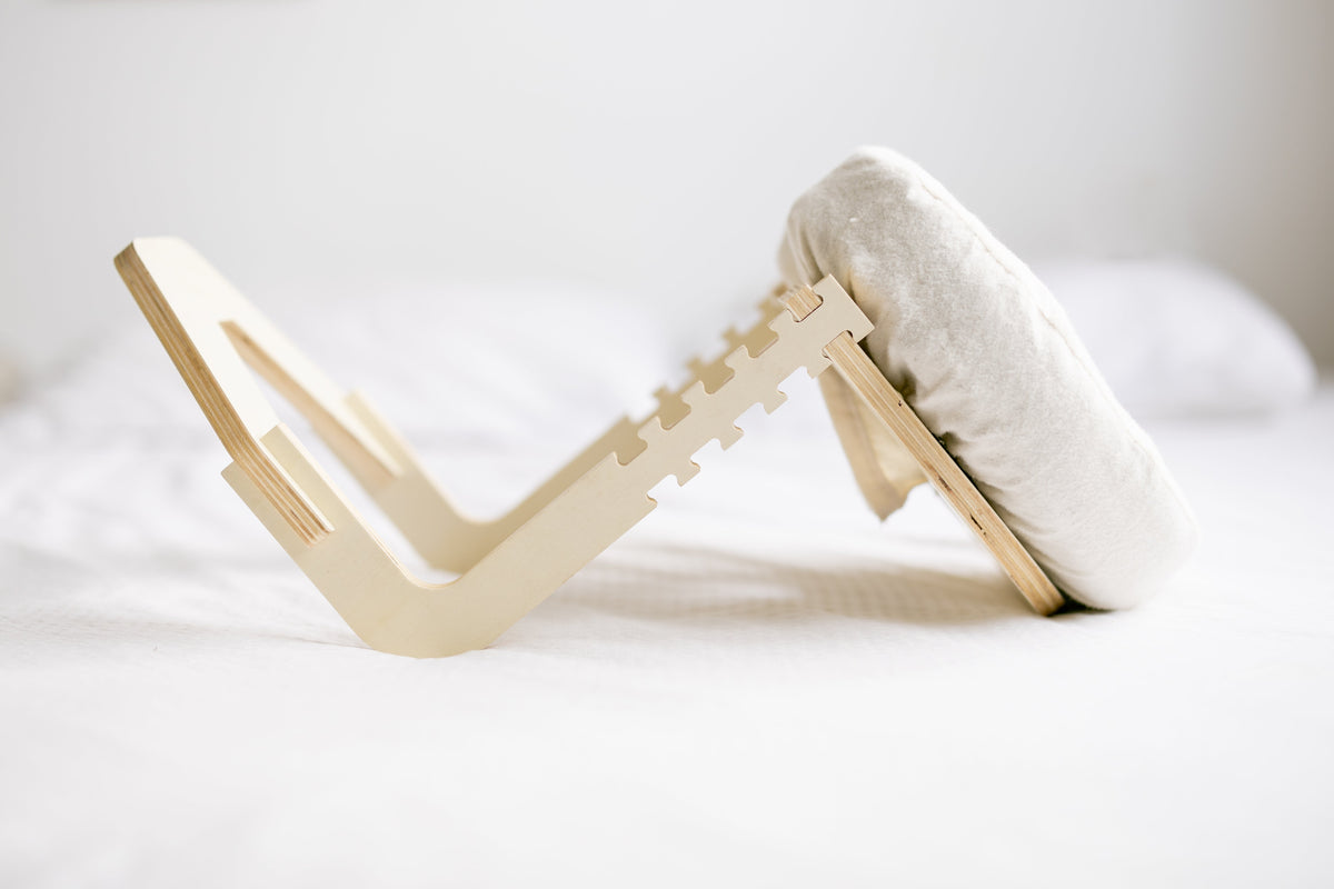 Het opengeklapte houten frame op een wit bed