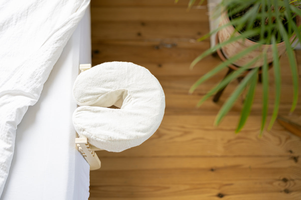 Het hoofdkussen van bovenaf, met een houten vloer en een plant eronder