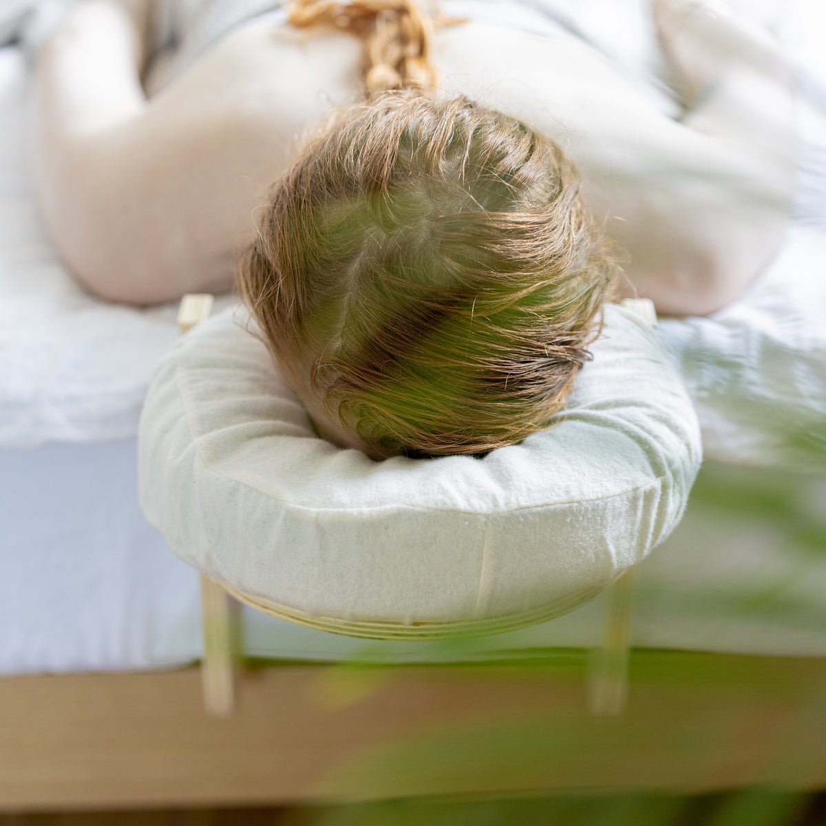 Bovenaanzicht van het hoofdkussen met de katoenen hoes op het houten frame